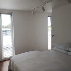 White blinds which complenebt the rest of snowy white room